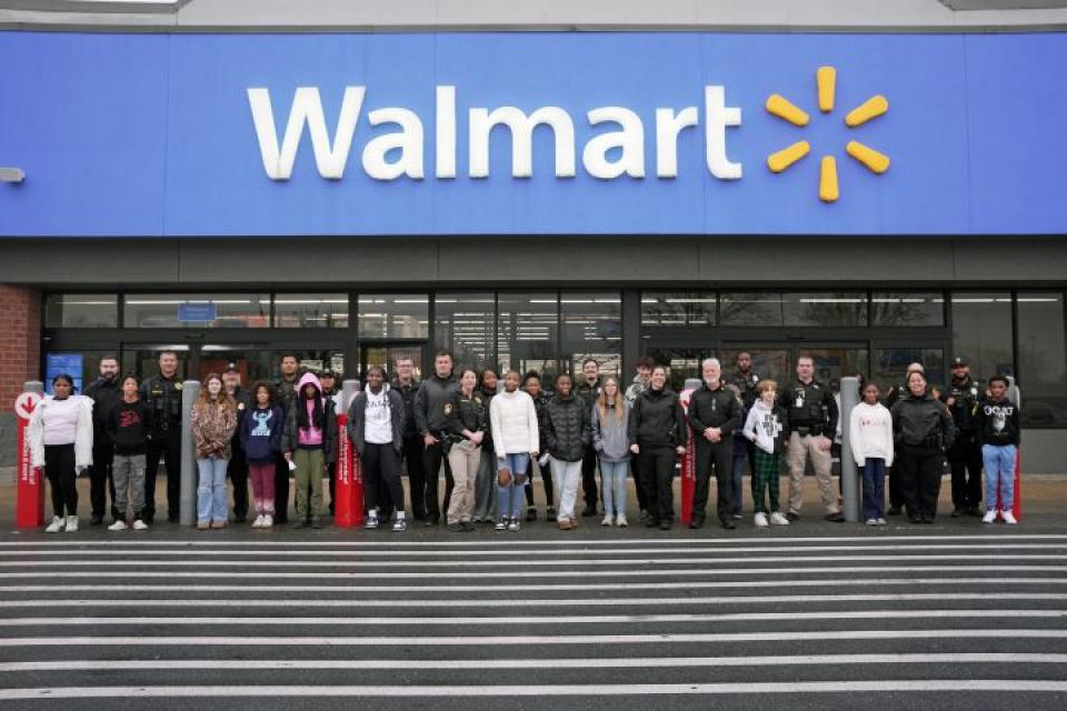 Officers from Easton Police Department and the Talbot County Sheriff’s Office stand with their “Shop with a Cop” companions in front of the Wal-Mart in Easton.