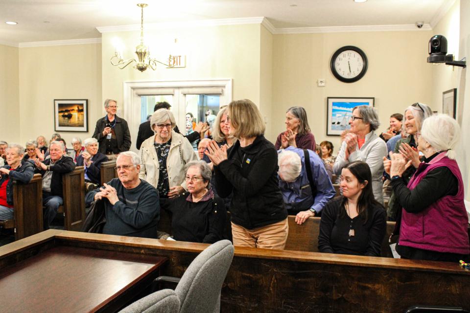 Crowd claps for teacher of the year.