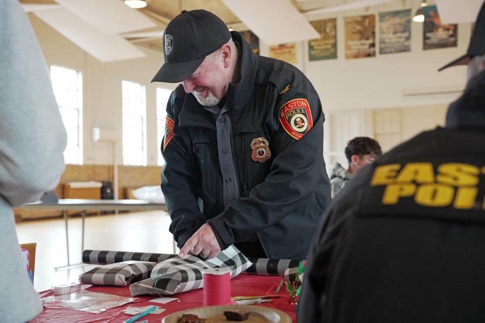 Easton Chief of Police Alan Lowrey helps to wrap gifts purchased at the Talbot Optimist Club's 'Shop With a Cop' event.